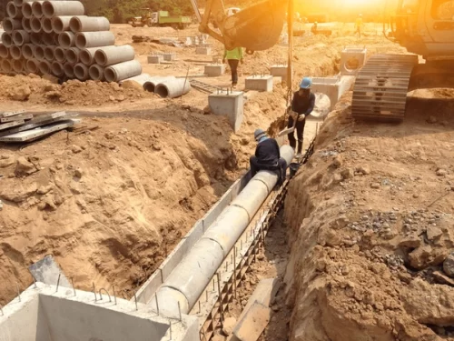 two-workers-installing-concrete-drains-600nw-655457224